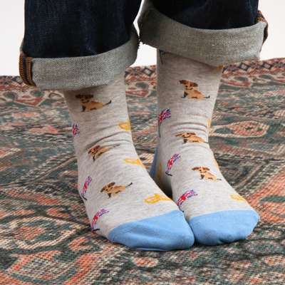 Gray socks with dog pattern worn by a person on a patterned rug