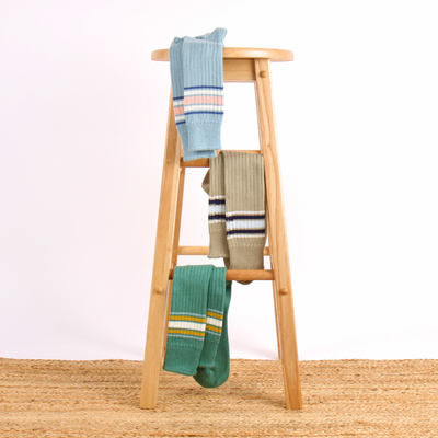 Wooden ladder with colourful socks on a white background