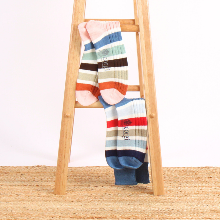 Colorful striped socks on a wooden ladder against a white background