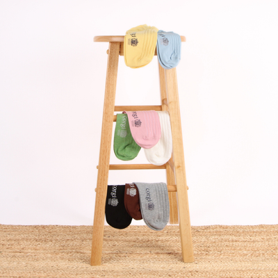 Colorful socks hanging on a wooden ladder against a white background