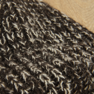 Close-up of a textured brown fabric on a wooden surface