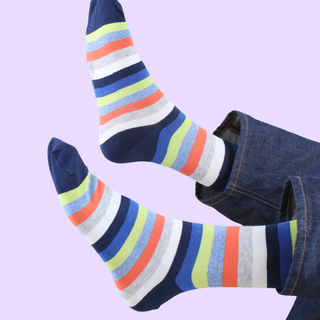 Colourful striped socks with a denim legs on a light purple background
