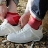Red men's trainer socks with a striped pattern worn with trainers