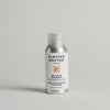 A travel-sized 50ml bottle of Cashmere & Wool detergent by The Clothes Doctor, with a white label and orange accents, on a light background.