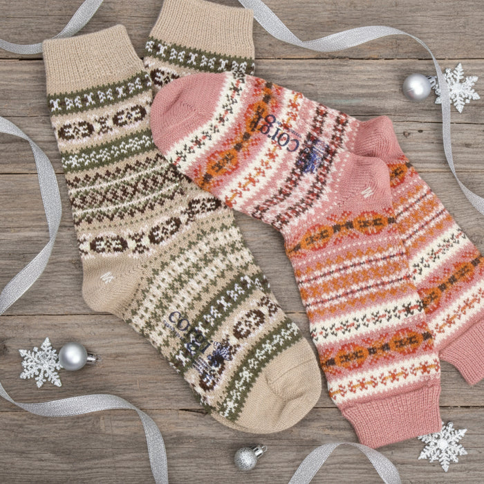 Two pairs of patterned socks, one beige with brown and white designs and the other pink with orange patterns, on a white background.