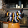 Striped socks being worn, with a fireplace and candles in the background