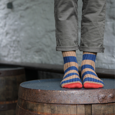 Person wearing striped socks with a rustic background