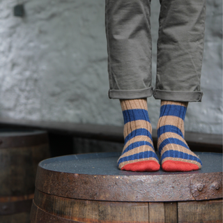 Person wearing striped socks with a rustic background