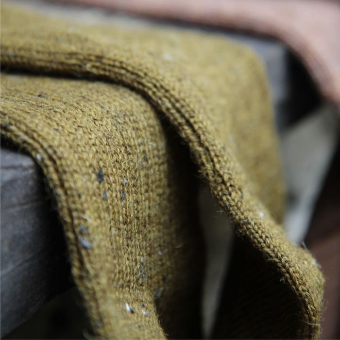 Close-up of a textured green fabric with a blurred background