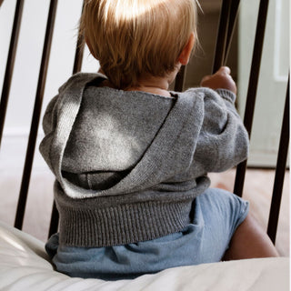 A sumptuous, grey button-down hooded cardigan for baby available in both wool and cashmere is a special treat that every new parent and baby will love, by Corgi Socks.