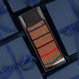 Striped sock in a box with blue gift boxes in the background