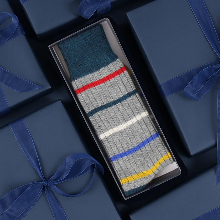 Striped sock in a box with blue ribbons on a matching background