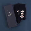 A pair of navy blue cashmere socks with a monogram pattern, showing the socks' texture and the brand name 'Corgi'.