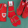 Red sports jersey, socks, and shoes with a visible brand logo on a green background