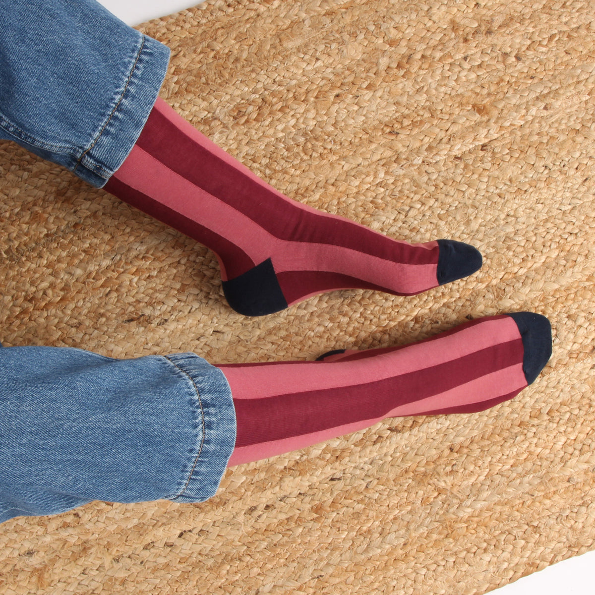 Red socks with black toes and heels worn on a textured surface