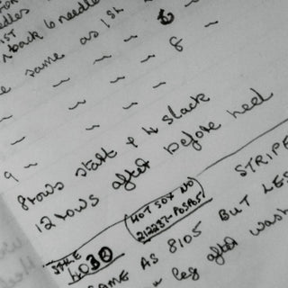 Handwritten notes on a piece of paper with text and numbers.